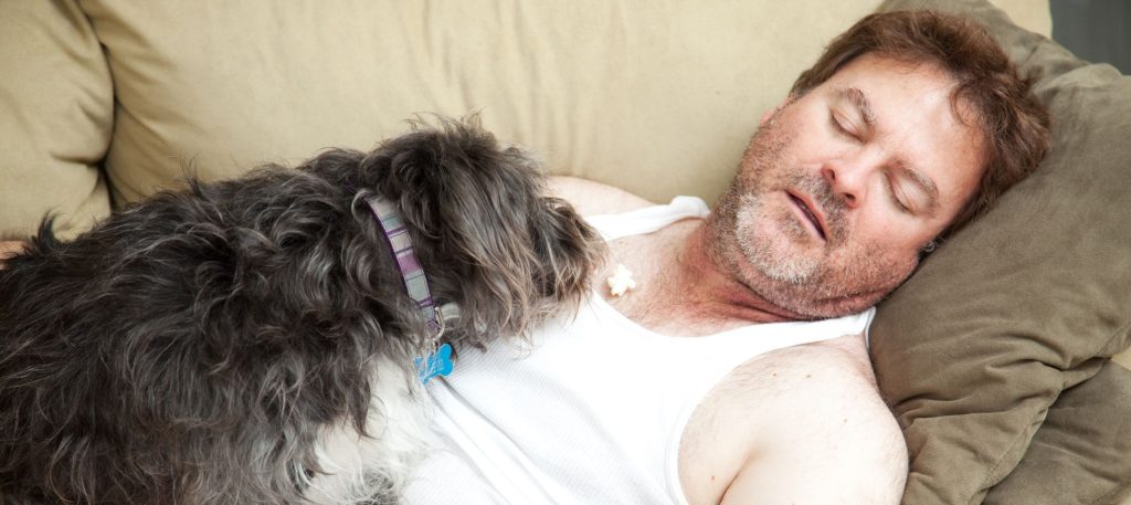 A man sleeping on the couch with his dog watching him--if he has taken ISO, he could be overdosing. 