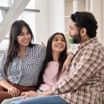 Parents on couch talking with their daughter.