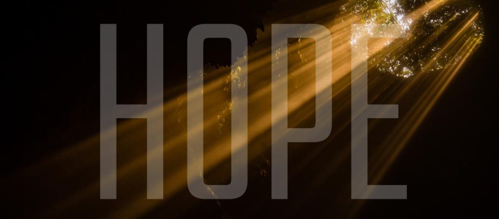Light shining through a hole with the word "HOPE" superimposed over image