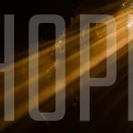 Light shining through a hole with the word "HOPE" superimposed over image